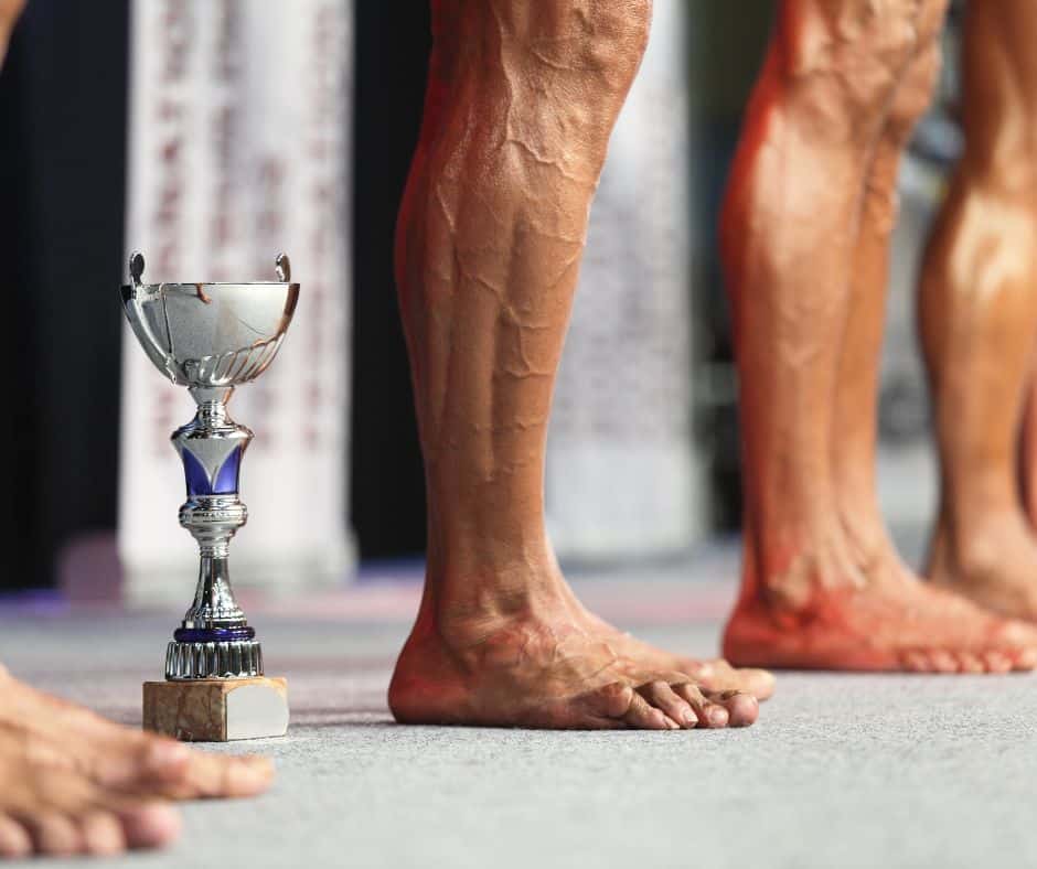 strong man championship lineup of legs with trophy