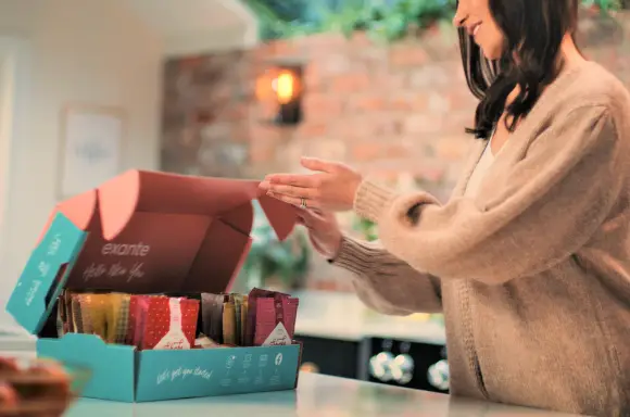 woman opening box of exante meal replacements in kitchen